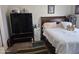 Cozy bedroom with soft lighting, comfortable bed, and functional wardrobe unit and dresser for storage at 7920 W Glendale Ave # 39, Glendale, AZ 85303