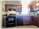 Traditional kitchen featuring wood cabinets, tile floors, and updated appliances at 7920 W Glendale Ave # 39, Glendale, AZ 85303