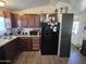 Galley kitchen featuring wooden cabinets and modern appliances, including a black refrigerator at 7920 W Glendale Ave # 39, Glendale, AZ 85303