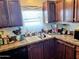 Kitchen with dark cabinetry, a double basin sink, and a lace trimmed window at 7920 W Glendale Ave # 39, Glendale, AZ 85303