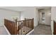 Upstairs hallway with wooden banister, neutral carpet, and bathroom view with glass shower door at 1125 E San Carlos Way, Chandler, AZ 85249