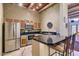 Well-equipped kitchen with stainless steel appliances, breakfast bar, and unique wood-beamed ceiling at 11333 N 92Nd St # 1118, Scottsdale, AZ 85260