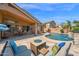 Inviting backyard pool with a beautiful waterfall feature and stylish outdoor furniture under a covered patio at 1144 E Nunneley Rd, Gilbert, AZ 85296