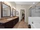 Elegant bathroom showcasing double sinks, granite counters, a tub, and a glass-enclosed shower at 1144 E Nunneley Rd, Gilbert, AZ 85296