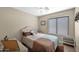 Comfortable bedroom with a ceiling fan, window, and neutral color scheme at 1144 E Nunneley Rd, Gilbert, AZ 85296