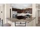 Modern kitchen features dark cabinetry, granite countertops, stainless steel appliances, and a breakfast bar at 1144 E Nunneley Rd, Gilbert, AZ 85296
