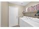 Functional laundry room with washer, dryer, and storage shelves for supplies at 1144 E Nunneley Rd, Gilbert, AZ 85296