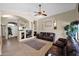 Inviting living room with plush leather seating, custom shelving, and a ceiling fan at 1144 E Nunneley Rd, Gilbert, AZ 85296