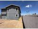 View of backyard and side of gray two-story home with brick patio and block wall at 121 N Brown Ave, Casa Grande, AZ 85122