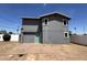 Back of a two-story gray home with a brick patio and fenced yard at 121 N Brown Ave, Casa Grande, AZ 85122
