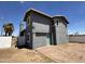 Gray two-story home with a green door, brick patio, and well-lit exterior at 121 N Brown Ave, Casa Grande, AZ 85122