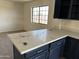 Kitchen island with dark cabinets and light countertops, next to a window at 121 N Brown Ave, Casa Grande, AZ 85122