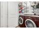 Well-organized laundry room with shelving, maroon washer and dryer, and white doors at 121 N California St # 35, Chandler, AZ 85225