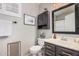 Well-lit bathroom featuring a dark vanity, framed mirror, decorative plant, and a toilet at 1282 N Banning St, Gilbert, AZ 85234