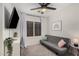 Cozy bedroom features a gray futon, a ceiling fan, bright windows, and neutral decor at 1282 N Banning St, Gilbert, AZ 85234