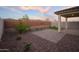 The backyard features desert landscaping, a brick wall, artificial turf, and a covered patio at 13195 N 145Th Ln, Surprise, AZ 85379