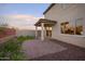 Covered patio with an artificial turf area surrounded by desert landscaping in this cozy backyard at 13195 N 145Th Ln, Surprise, AZ 85379