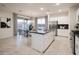 Bright, open kitchen with white cabinets, stainless steel appliances, and dining area at 13195 N 145Th Ln, Surprise, AZ 85379
