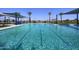 Large community pool features a splash pad, shade coverings, palm trees and lounge chairs at 13195 N 145Th Ln, Surprise, AZ 85379