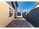View of the backyard with a brick-paved driveway, detached garage, and perimeter privacy fence at 1338 E Granada Rd, Phoenix, AZ 85006
