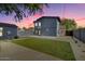 Spacious backyard with artificial grass, a tall fence, and a modern two-story addition at 1338 E Granada Rd, Phoenix, AZ 85006