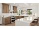Modern kitchen featuring a stylish island with seating, stainless steel appliances, and subway tile backsplash at 1338 E Granada Rd, Phoenix, AZ 85006