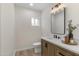 Modern bathroom featuring a wood vanity with white countertop and stylish light fixture at 1367 E Mitchell Dr, Phoenix, AZ 85014