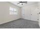 A clean bedroom featuring a ceiling fan, plush carpet, and a well-lit window at 1367 E Mitchell Dr, Phoenix, AZ 85014