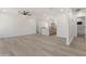 Open-concept living area showcasing hardwood floors, white walls, and a seamless transition into the kitchen and bathroom at 1367 E Mitchell Dr, Phoenix, AZ 85014