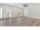 Bright living room featuring hardwood floors, a modern ceiling fan, and a view of the front yard at 1367 E Mitchell Dr, Phoenix, AZ 85014