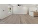 Spacious living room with hardwood floors, neutral walls, large window, and ceiling fan with open layout to kitchen at 1367 E Mitchell Dr, Phoenix, AZ 85014