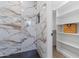 Shower with tile surround, built-in niche, herringbone floor, and access to closet at 1367 E Mitchell Dr, Phoenix, AZ 85014