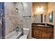 Bright bathroom featuring a shower and tub combo, tiled wall, and wooden vanity with granite countertop at 14598 E Corrine Dr, Scottsdale, AZ 85259