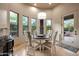 Bright dining area with a modern chandelier and an outdoor view through the many windows at 14598 E Corrine Dr, Scottsdale, AZ 85259