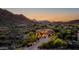 Stunning exterior shot of a desert home nestled in the mountains with a beautiful dusk sky at 14598 E Corrine Dr, Scottsdale, AZ 85259
