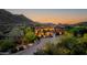 Stunning exterior elevation of a luxury home with lush landscaping and mountain views at sunset at 14598 E Corrine Dr, Scottsdale, AZ 85259