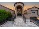 Grand front entrance of a custom home, featuring an arched tower, custom ironwork door, and lush landscape at 14598 E Corrine Dr, Scottsdale, AZ 85259