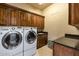 Functional laundry room with modern washer and dryer and ample storage at 14598 E Corrine Dr, Scottsdale, AZ 85259