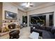 A living room featuring a stone fireplace, a ceiling fan, and views of the outdoor patio at 14598 E Corrine Dr, Scottsdale, AZ 85259