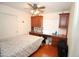 This bedroom includes a ceiling fan, wood floors, and built-in cabinets and desk for storage at 16251 N 91St Dr, Peoria, AZ 85382