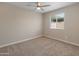 Neutral bedroom featuring tan walls, carpet, ceiling fan, and a window at 1808 W Rose Ln, Phoenix, AZ 85015