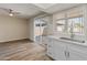 Bright eat-in kitchen with sliding glass doors, modern white cabinets and countertops, and wood-look flooring at 1808 W Rose Ln, Phoenix, AZ 85015