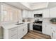 Bright, updated kitchen with white cabinets, stainless steel appliances, quartz countertops, and wood-look flooring at 1808 W Rose Ln, Phoenix, AZ 85015