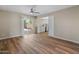 Bright living room featuring wood-look flooring, ceiling fan, and sliding glass door access to the patio at 1808 W Rose Ln, Phoenix, AZ 85015