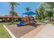 Community playground featuring a blue playset with slides and shade under a bright blue sky at 1808 W Rose Ln, Phoenix, AZ 85015