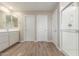 Bathroom with double doors, wood look tile floor, walk-in shower and large vanity at 18351 W Patrick Ln, Surprise, AZ 85387
