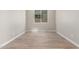 An empty bedroom shows the wood-look tile floor, baseboards, and neutral wall paint at 18351 W Patrick Ln, Surprise, AZ 85387
