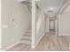 Inviting entryway with carpeted stairs, light tile flooring, and neutral paint throughout at 18351 W Patrick Ln, Surprise, AZ 85387