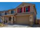 Charming two-story home featuring a two-car garage, red shutters, and desert landscaping at 18351 W Patrick Ln, Surprise, AZ 85387