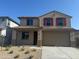 Charming two-story home featuring a desert landscape, attached two-car garage, and red shutters on the front windows at 18351 W Patrick Ln, Surprise, AZ 85387